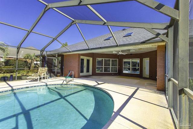 view of swimming pool with a patio area, ceiling fan, and glass enclosure