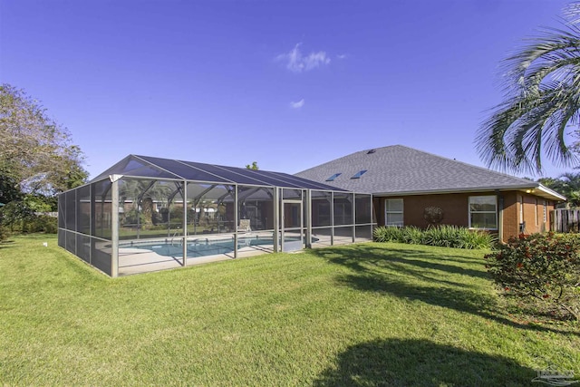 rear view of property with a lanai and a lawn