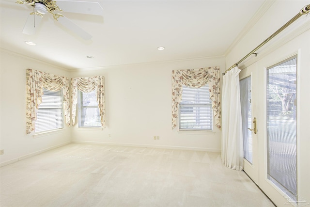 carpeted spare room with crown molding, plenty of natural light, and ceiling fan