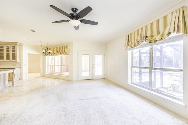 unfurnished living room with crown molding, plenty of natural light, ceiling fan with notable chandelier, and light carpet