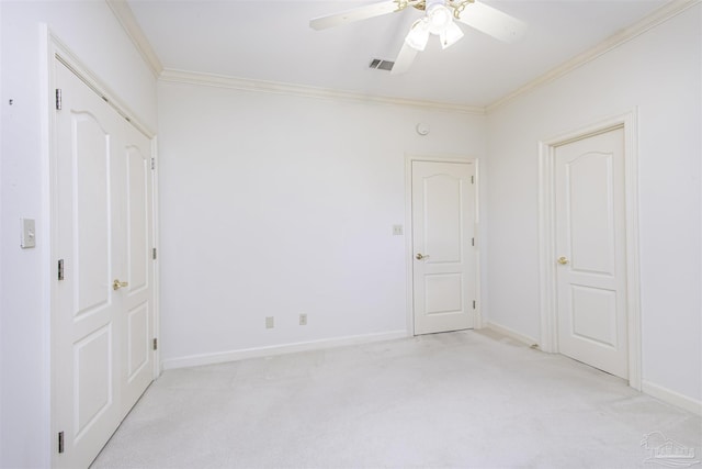 unfurnished bedroom featuring light colored carpet, ornamental molding, and ceiling fan