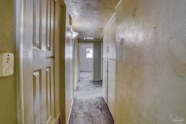 hallway with light carpet and a textured ceiling