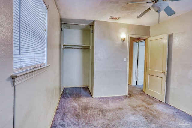 unfurnished bedroom featuring ceiling fan, light colored carpet, and a closet