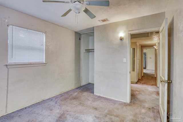 unfurnished bedroom with light carpet, a closet, and ceiling fan