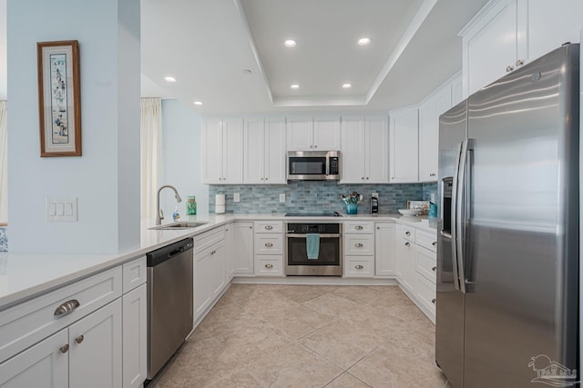 kitchen with stainless steel appliances, white cabinetry, sink, and tasteful backsplash