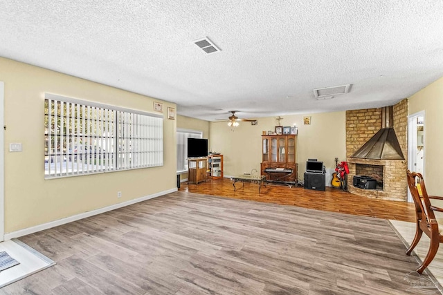 unfurnished living room with wood-type flooring, ceiling fan, and a textured ceiling