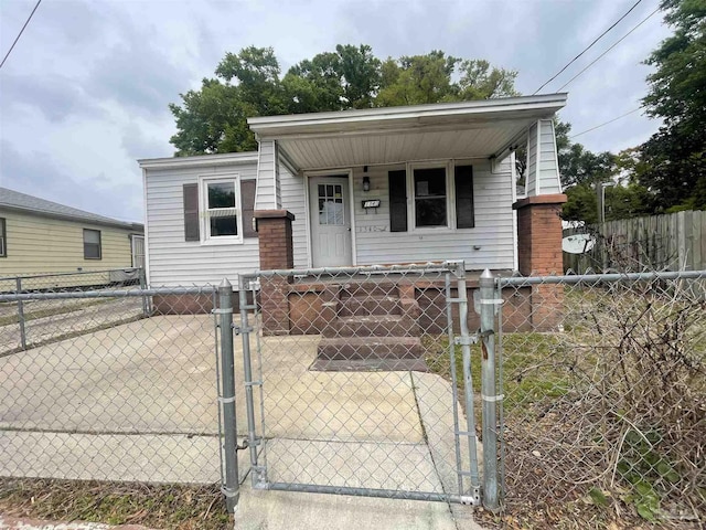 view of front facade with a fenced front yard, a gate, and a porch