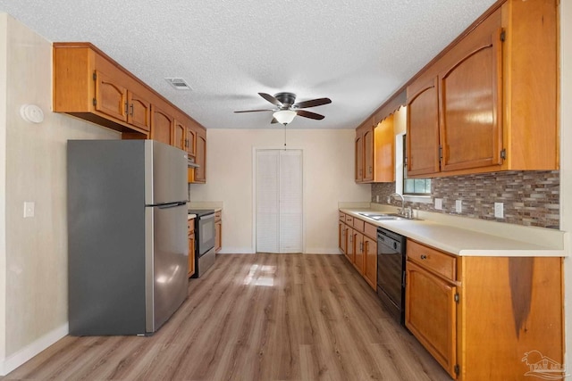 kitchen featuring ceiling fan, sink, light hardwood / wood-style flooring, a textured ceiling, and black appliances