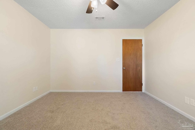 empty room with carpet flooring, ceiling fan, and a textured ceiling