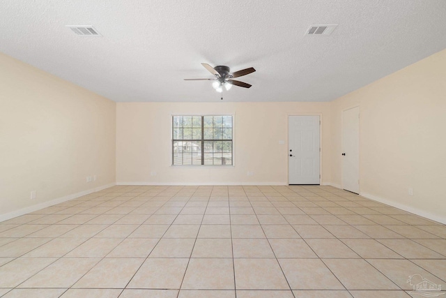 empty room featuring ceiling fan, light tile patterned flooring, and a textured ceiling