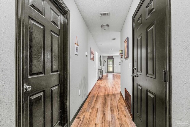 kitchen featuring light wood-type flooring, pendant lighting, dark brown cabinets, light stone counters, and ceiling fan