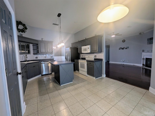 kitchen with stainless steel appliances, tasteful backsplash, light wood-type flooring, and ceiling fan