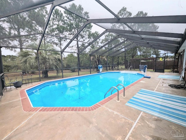 view of swimming pool with glass enclosure and a patio area