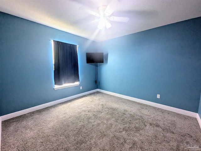 carpeted empty room featuring ceiling fan