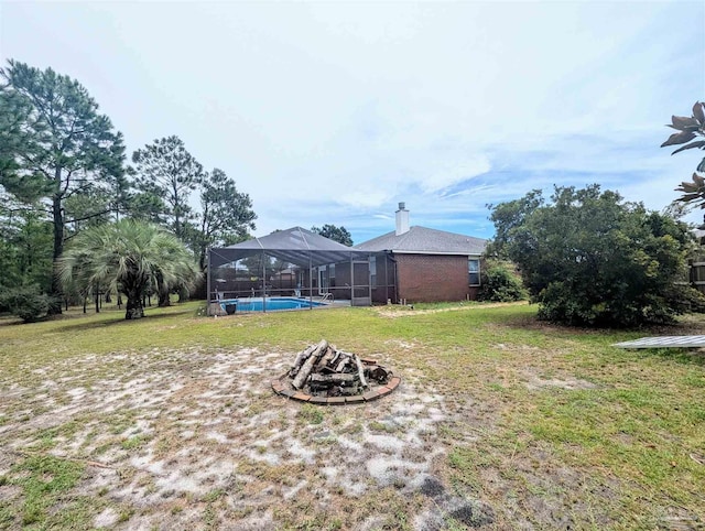 view of yard with an outdoor fire pit and a lanai