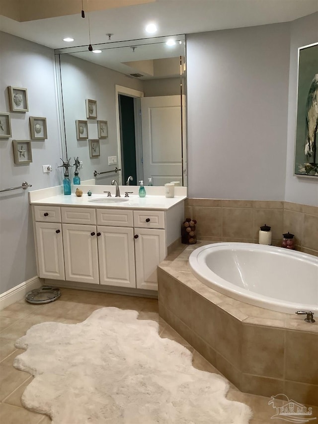 bathroom featuring vanity, tiled bath, and tile patterned flooring