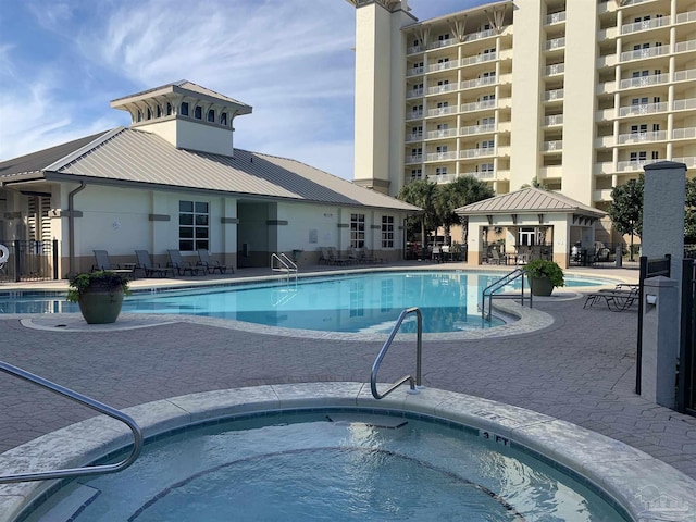 view of swimming pool featuring a gazebo, a community hot tub, and a patio area