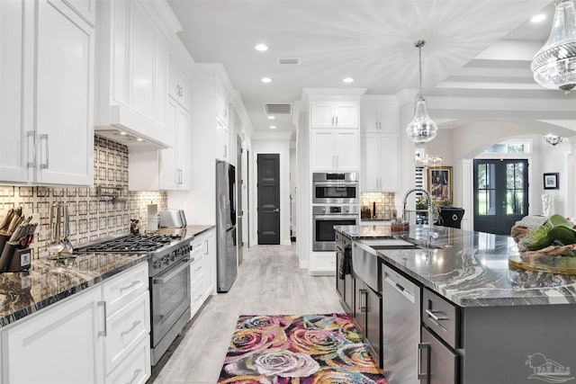 8780 Spider Lily Way, Pensacola, FL 32526 - kitchen with appliances with stainless steel finishes, a sink, arched walkways, decorative backsplash, and visible vents