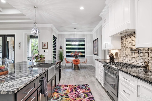 8780 Spider Lily Way, Pensacola, FL 32526 - kitchen with white cabinets, a notable chandelier, appliances with stainless steel finishes, a sink, and backsplash