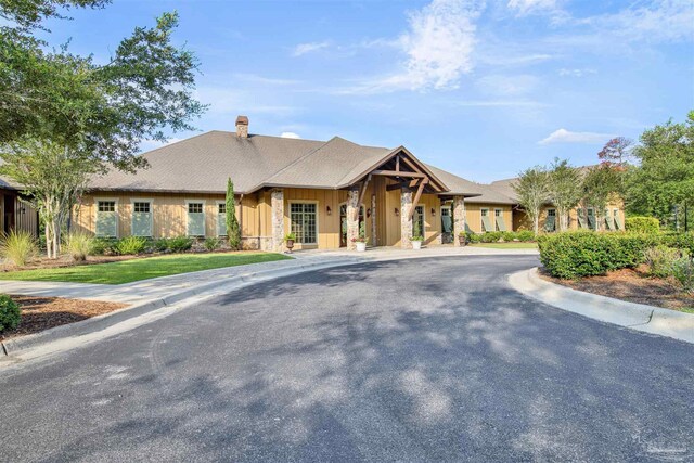 8780 Spider Lily Way, Pensacola, FL 32526 - view of front of home featuring board and batten siding, stone siding, and a chimney