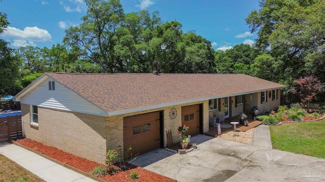 200 Talladega Trl, Pensacola, FL 32506 - view of front facade with driveway, an attached garage, roof with shingles, brick siding, and a porch
