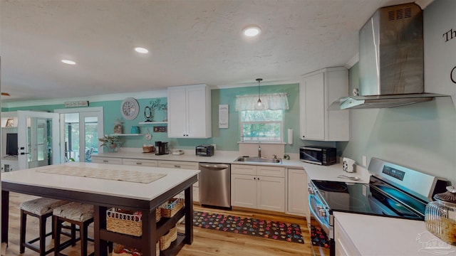 200 Talladega Trl, Pensacola, FL 32506 - kitchen with stainless steel appliances, wall chimney exhaust hood, a sink, white cabinetry, and crown molding