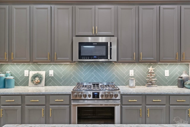 1397 Sabal Palm Dr, Gulf Breeze, FL 32563 - kitchen with gray cabinets, backsplash, and stainless steel appliances