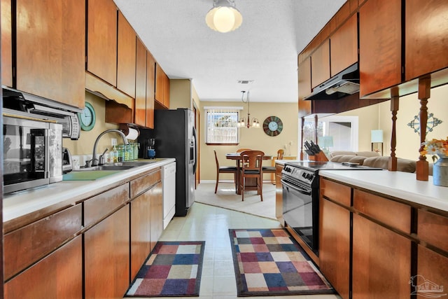 kitchen featuring light countertops, black range with electric cooktop, a sink, and under cabinet range hood