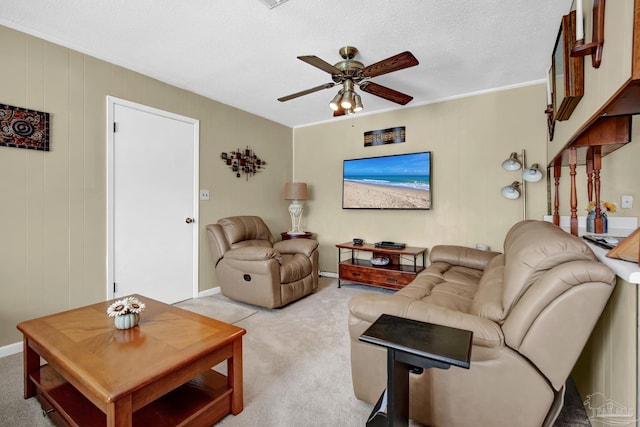 living room featuring light carpet, ceiling fan, and a textured ceiling