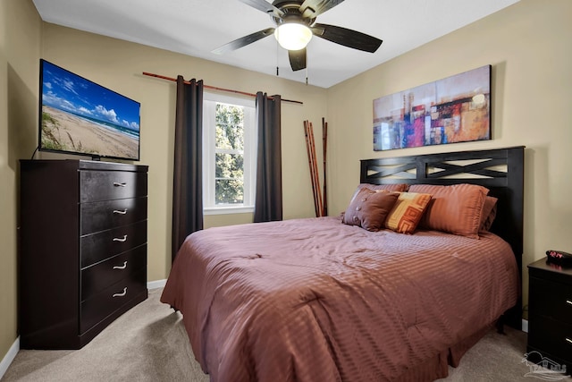 carpeted bedroom with ceiling fan and baseboards