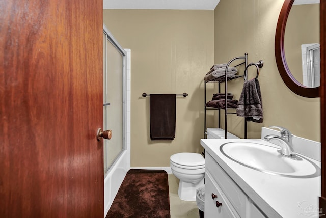 bathroom featuring bath / shower combo with glass door, vanity, toilet, and baseboards