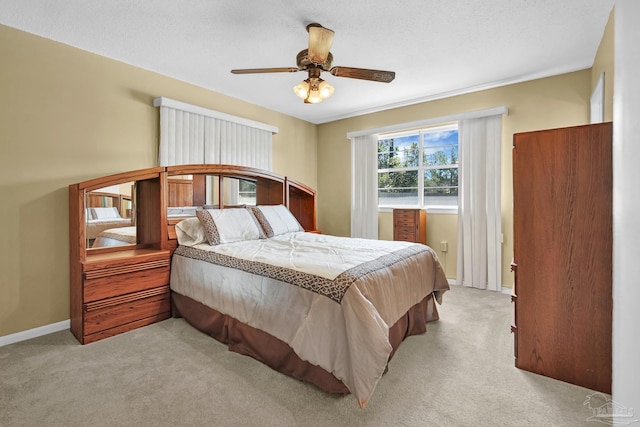 bedroom with ceiling fan, carpet floors, a textured ceiling, and baseboards