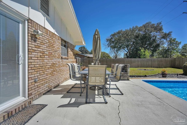 view of patio with a fenced in pool, outdoor dining area, and a fenced backyard