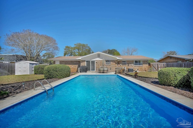 view of swimming pool featuring a fenced in pool, an outdoor structure, fence, and a storage shed