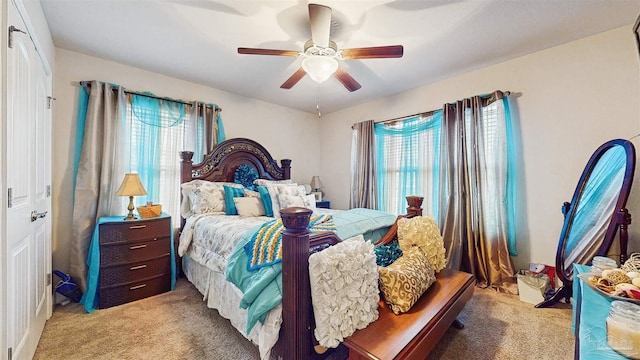 bedroom with multiple windows, light carpet, and ceiling fan