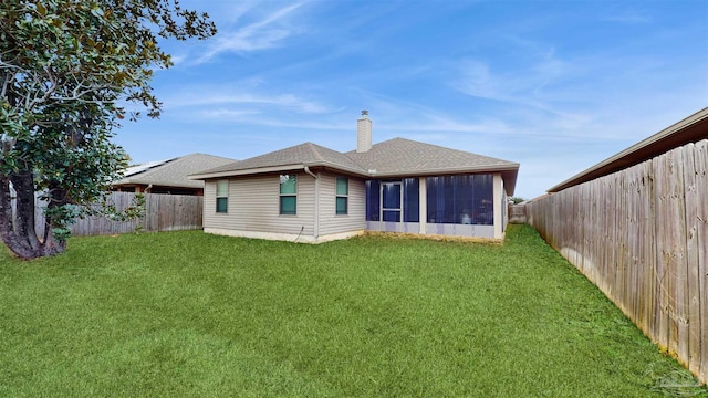 back of property with a sunroom and a lawn