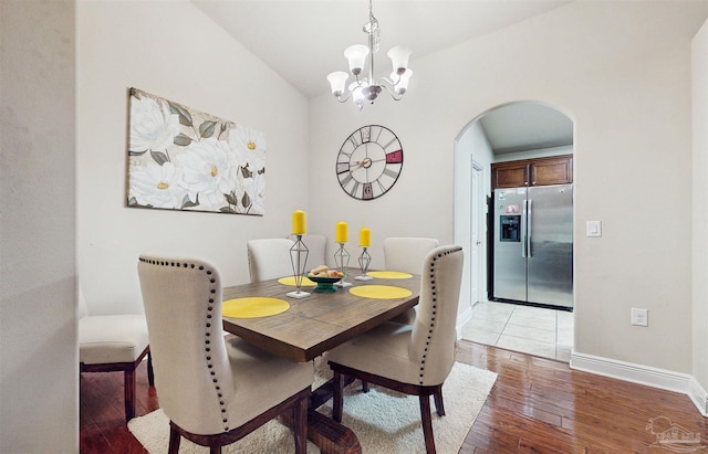 dining space with hardwood / wood-style floors and a notable chandelier