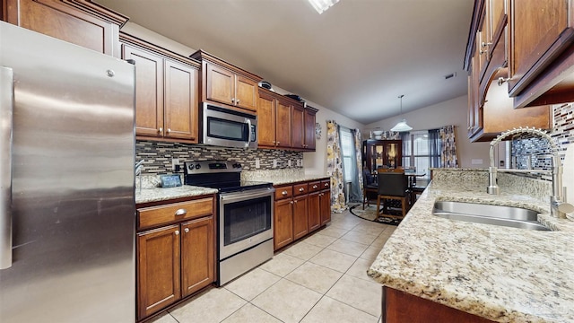 kitchen featuring sink, decorative light fixtures, light tile patterned floors, appliances with stainless steel finishes, and backsplash