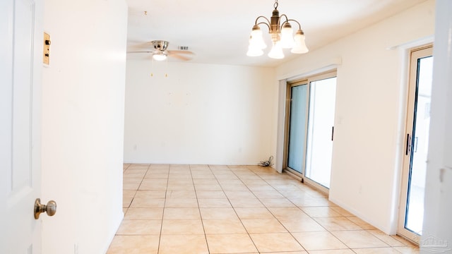 spare room with ceiling fan with notable chandelier and light tile patterned floors