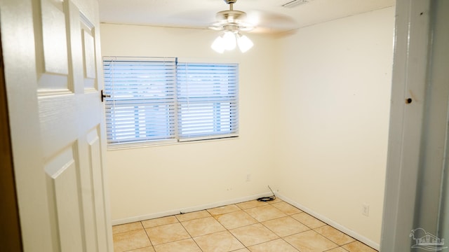 tiled spare room featuring ceiling fan