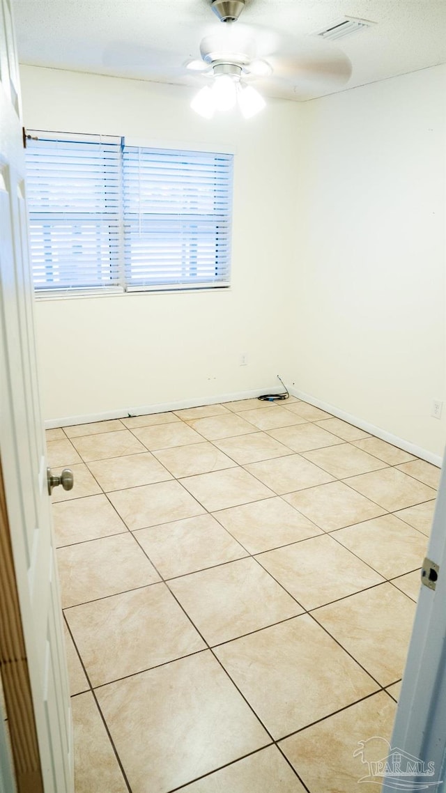 spare room with light tile patterned floors and ceiling fan