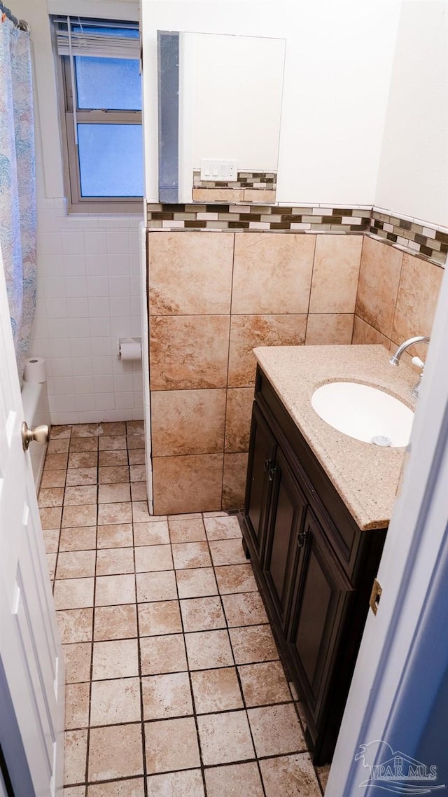 bathroom with vanity and tile walls