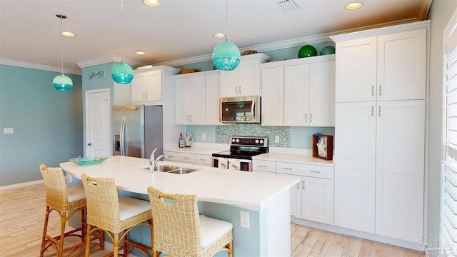 kitchen featuring stainless steel appliances, ornamental molding, a sink, and white cabinetry
