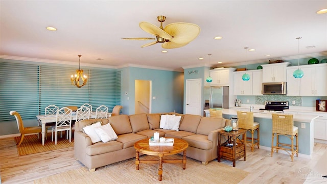 living area featuring recessed lighting, ornamental molding, ceiling fan with notable chandelier, and light wood finished floors