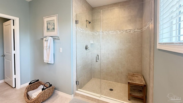 bathroom featuring baseboards and a shower stall