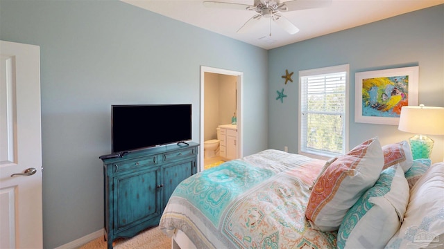 bedroom featuring a ceiling fan, baseboards, and ensuite bathroom