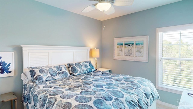 carpeted bedroom featuring baseboards, ceiling fan, and multiple windows