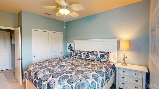 bedroom with ceiling fan, light colored carpet, visible vents, and a closet