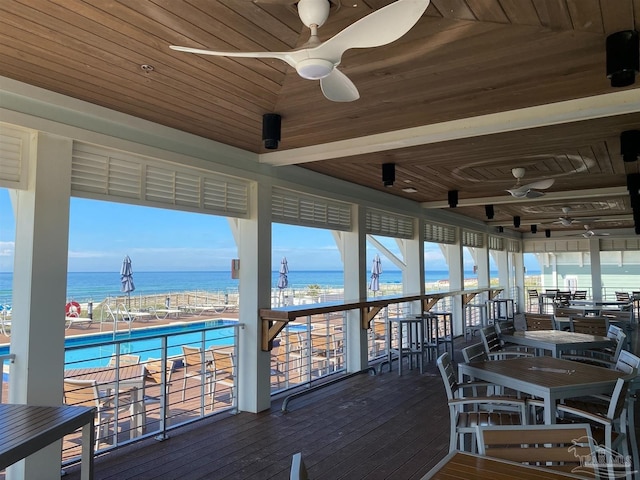 sunroom featuring a water view