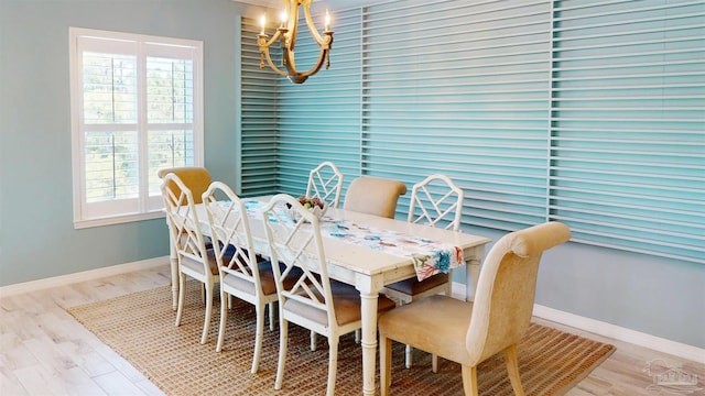 dining space with baseboards, wood finished floors, and a chandelier